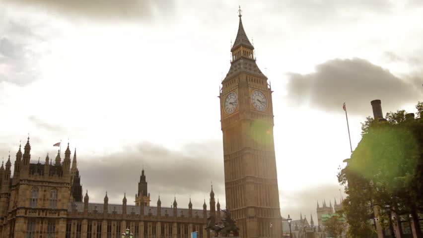 Big Ben and Westminster Abbey with cloudy sky background in London, England.
