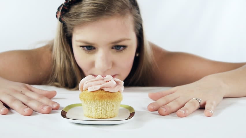 Girl at a table craving for a cup cake