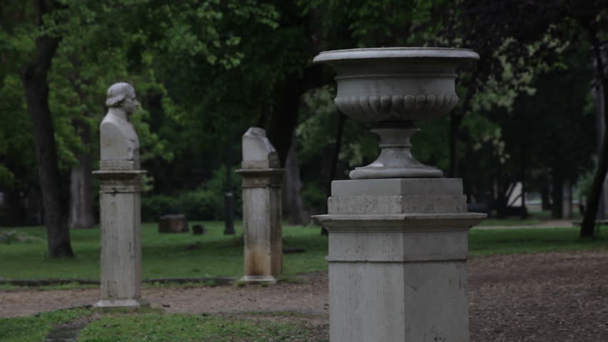 Shot of a statue and flower pot on pedistals