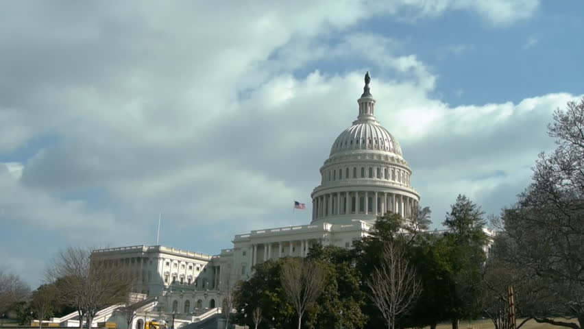 Zooming shot of US Capitol on hill in winter on cloudy sky background