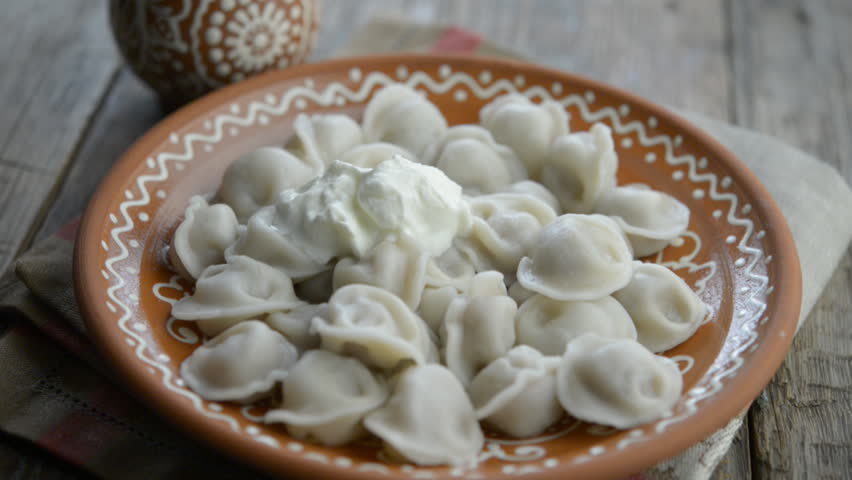 Pelmeni, traditional Russian dumplings with meat served with sour cream and dill