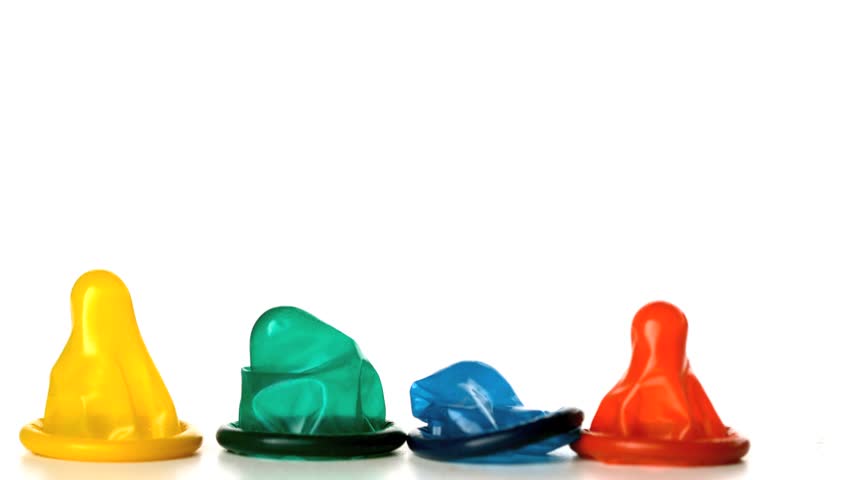 Four colourful condoms falling on white background in slow motion
