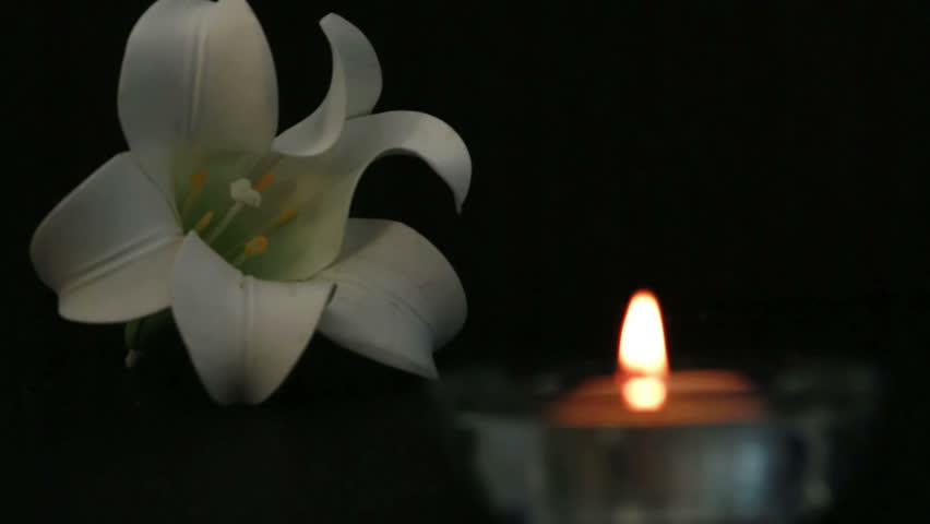 Candle lighting for remembrance with white lily flower