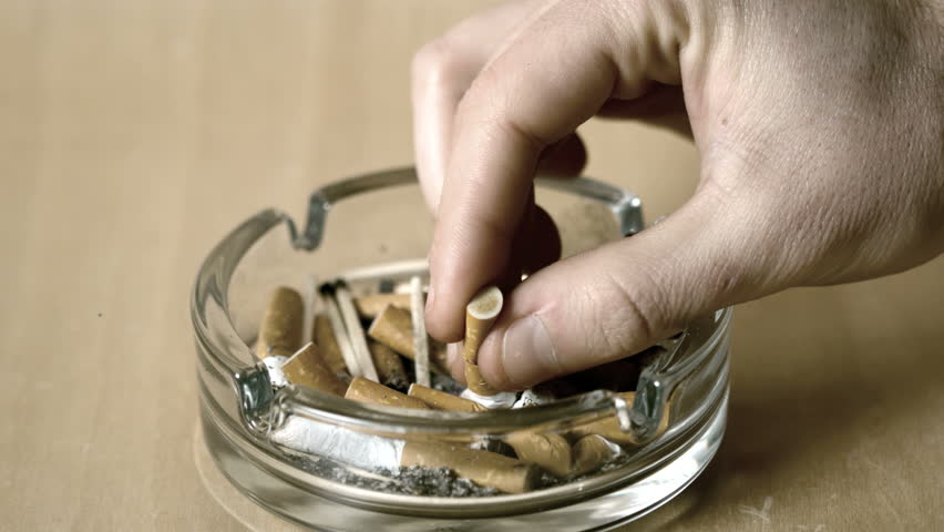 Man putting out cigarette in ashtray in slow motion