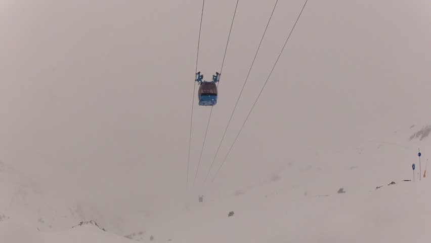 Cabin ski lift moving in the fog