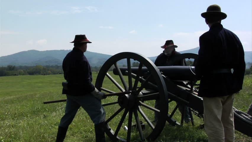 CHICKAMAUGA, GEORGIA - OCTOBER 2008 - large-scale, epic Civil War anniversary reenactment -- in the middle of battle.  Union Artillery battery fires their cannon from atop hill onto attacking Confederate infantry.