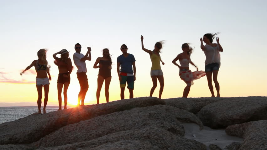 Young fun party people dancing at the beach. 