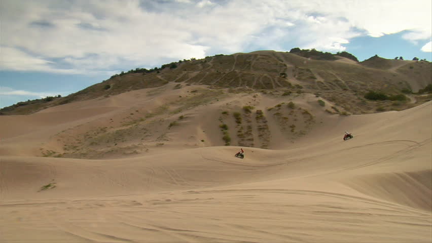 ATV riders on wide desert landscape