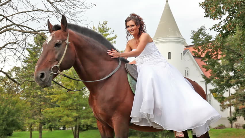 Beautiful bride posing on the brown horse and fears