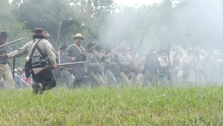 GEORGIA - OCTOBER 2008 - large-scale, epic Civil War anniversary reenactment -- in the middle of battle.  Confederate attack through smoky battlefield - lone Soldier runs in advance to fire -