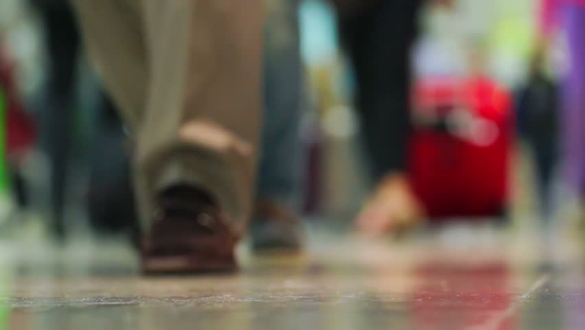 Crowd of people walking with luggage in the international airport, de-focused scene