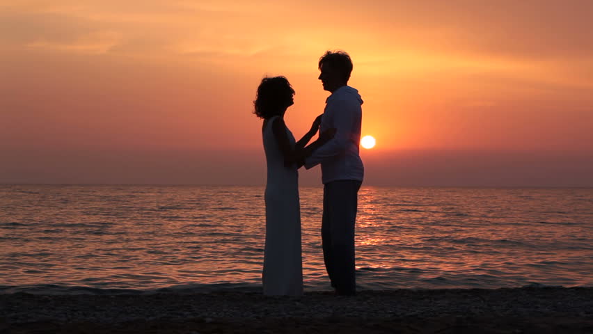 Romantic man and woman talking and having fun on the seaside. silhouette. 
