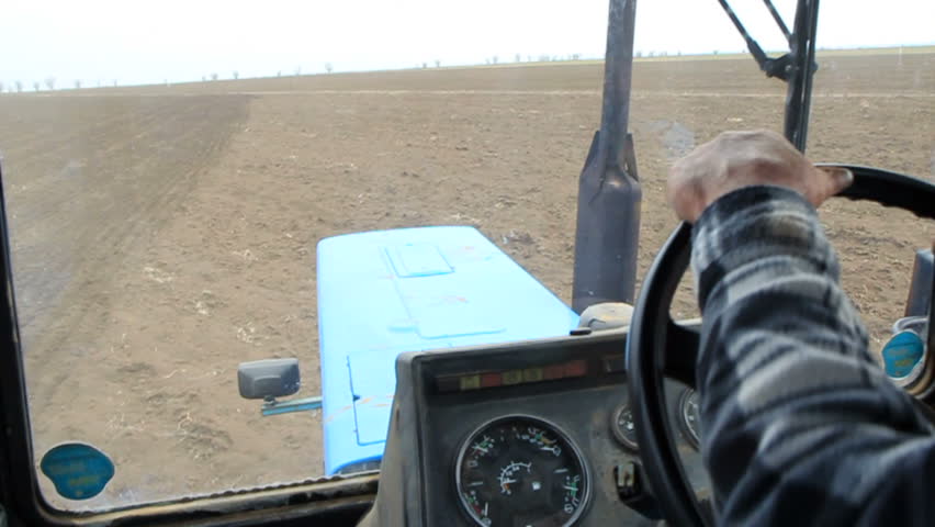 Farmer driving tractor,cultivating the field with a tractor plow.