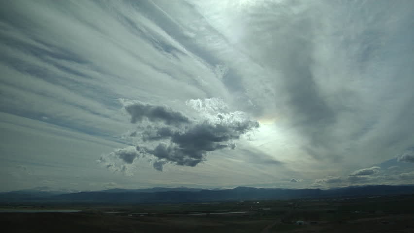 Jet Stream Roars Overhead. Cirrus clouds marking the core of the jet stream roar over the Rockies, while mountain wave clouds roil below