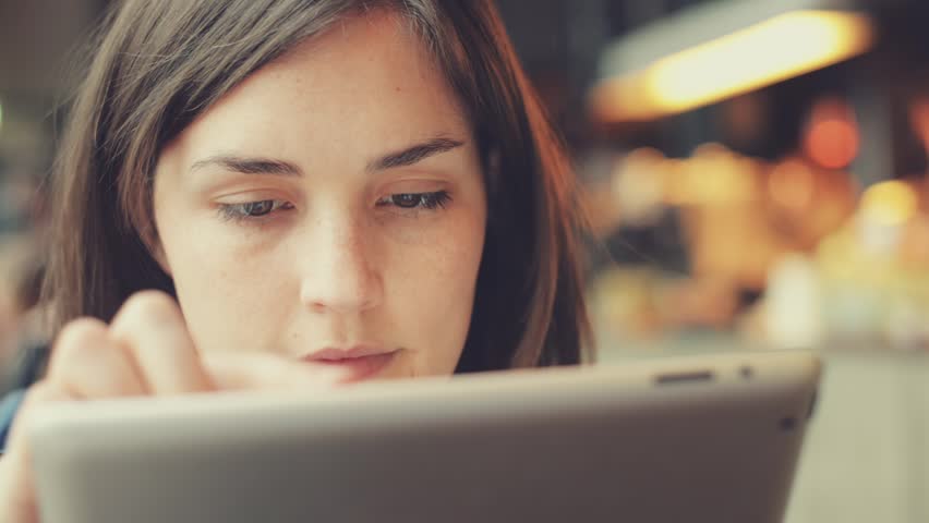 woman using tablet computer touchscreen in cafe