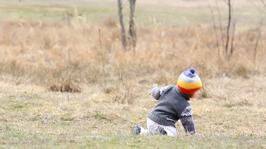 Lazy baby moving on his knees in the field