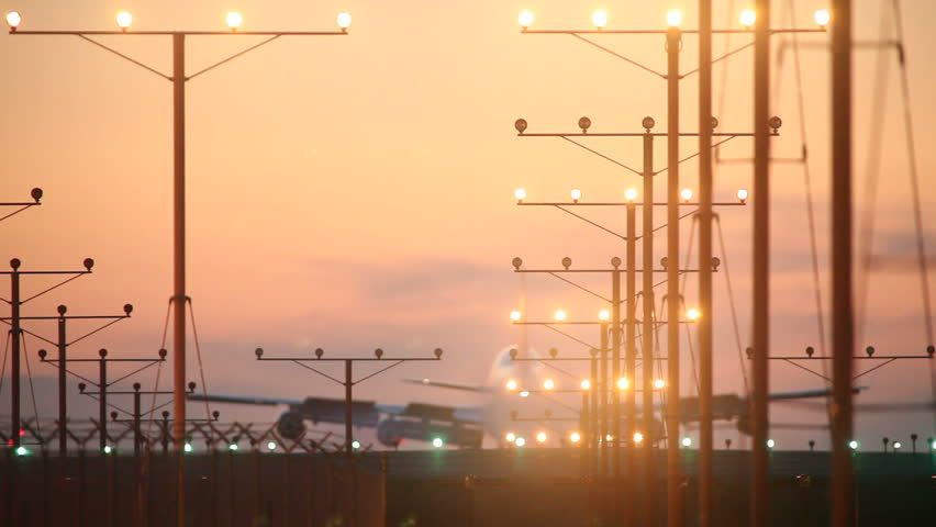 Big airplane landing in airport at sunset