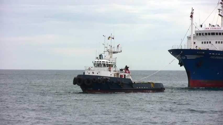 ALICANTE, SPAIN â APRIL 04: The tug "J. TORRES" is working with the general cargo vessel âTELEGHMAâ for entering in the port of Alicante; Spain; on april 04, 2013 in Alicante.