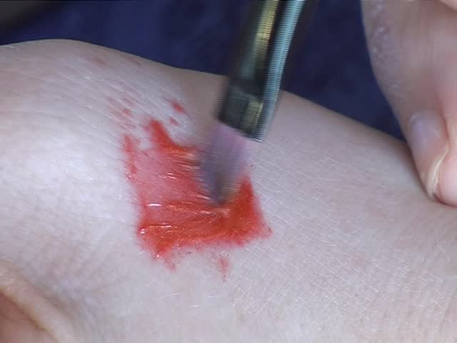 Make-up artist mixing lipstick on hand