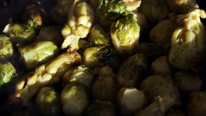 Chef stiring brussels sprouts on a frying-pan