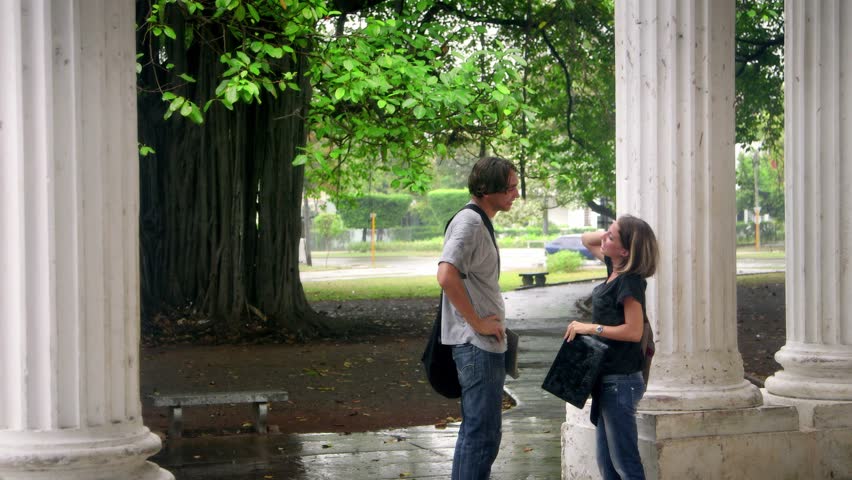 Students talking and smiling, boy and girl running in the rain during storm. Sequence
