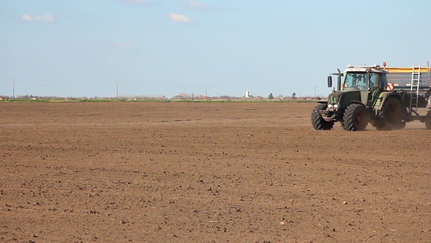 Agricultural tractor fertilize field with mineral fertilizers before sowing, for increase crop yields