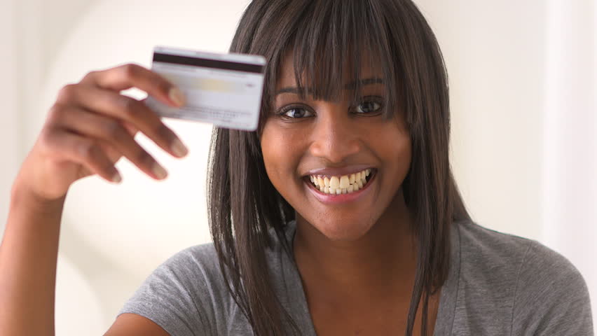 Black woman holding up credit card