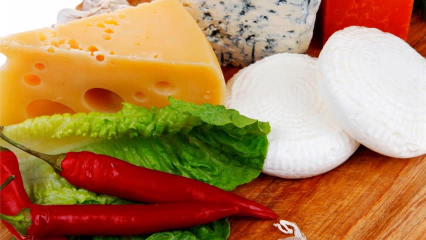 delicatessen french cheese on wooden board with hot peppers and dill 