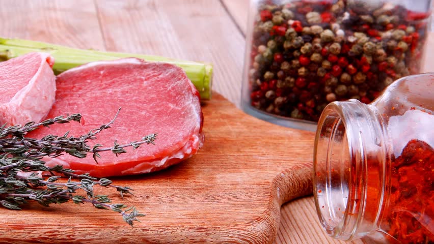 prime fillet meat : dry raw beef on cutting board with asparagus thyme bundle color peppercorn mix and red paprika powder mixed with dry spices over wooden table ready to cooking