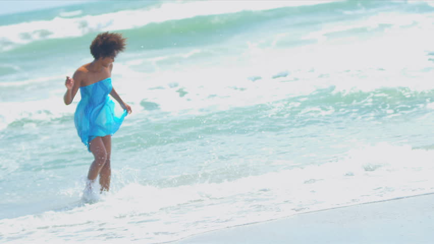 Pretty girl in sundress reveling being alone in ocean by beach vacation resort shot on RED EPIC