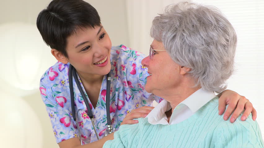 Asian nurse talking to Caucasian patient