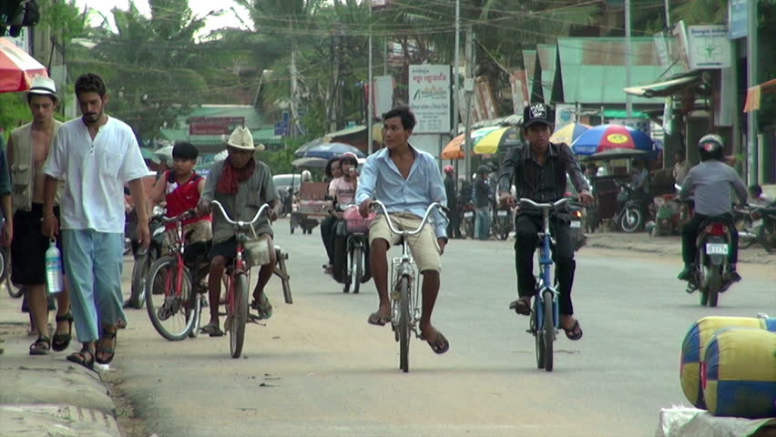 SIEM REAP, CAMBODIA - CIRCA JUNE 2011: A main street footage where local people and tourists walk down or pass through the street by car, bicycle, tuk-tuk and motorbike.