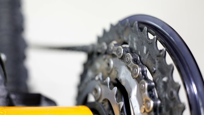 A man cleaning bicycle chain with cloth, later oiling the clean chain. Extreme closeup with macro tubes and high quality shoot.