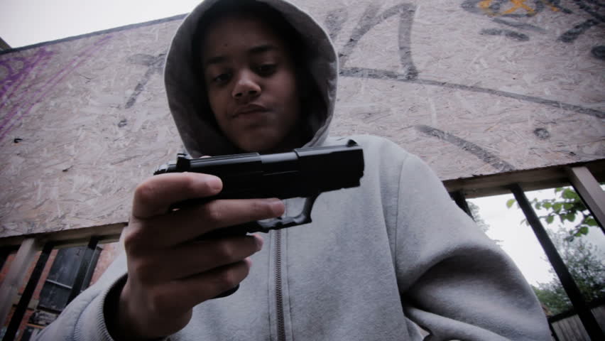 Teenage boy with a gun - wearing a hoodie