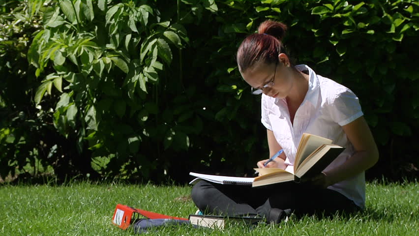 A student studying outdoors - with smile to camera