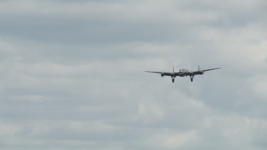 Avro Lancaster bomber plane from World War II landing at airfield.