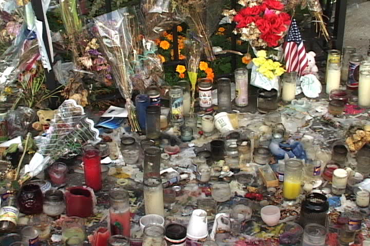 NEW YORK CITY - SEPTEMBER 29, 2001: Bouquets of flowers, American flags, and burned candles cover the ground in memory of 9/11.