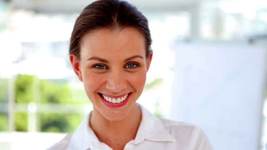 Businesswoman walking into focus before posing in front of the camera