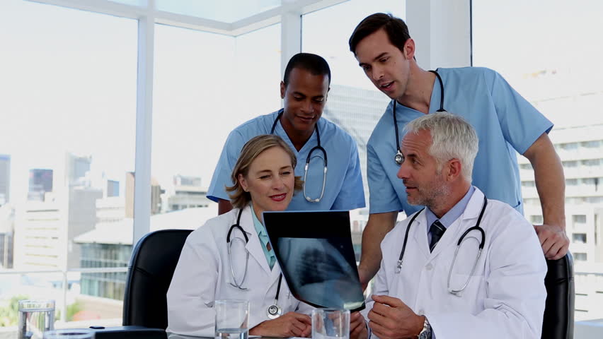 Group of doctors examining an x-ray together in a meeting room