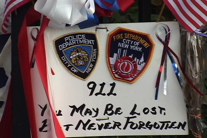 NEW YORK CITY - SEPTEMBER 29, 2001: Poster with flags and ribbon streamers left in tribute to police and firefighters, You May Be Lost But Never Forgotten