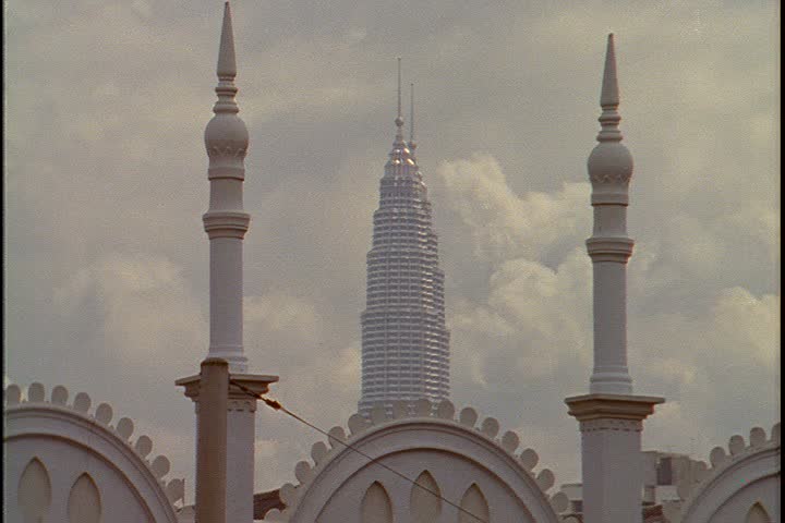 KUALA LUMPUR - OCTOBER 25, 1999: MS white minarets of the Kuala Lumpur railway station. Between the minarets are the tops of the Petronas Towers.