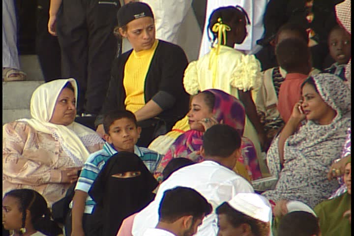 DUBAI - NOVEMBER 02, 2001: General views of Jebel Ali Race Course; MS group of women and children sitting in stands. Women wearing brightly colored head scarves, one is talking on cell phone.