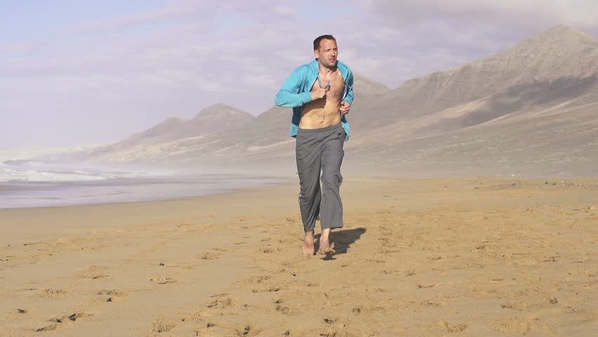 Young man jogging on beautiful beach
