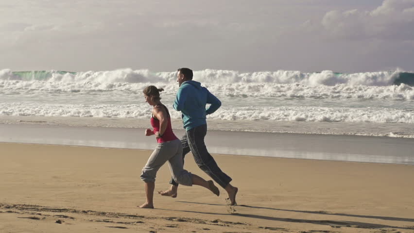 Couple jogging on the beach, super slow motion, shot at 240fps
