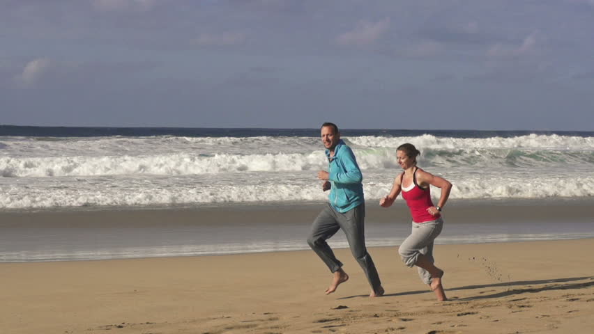 Couple jogging on the beach, super slow motion, shot at 240fps
