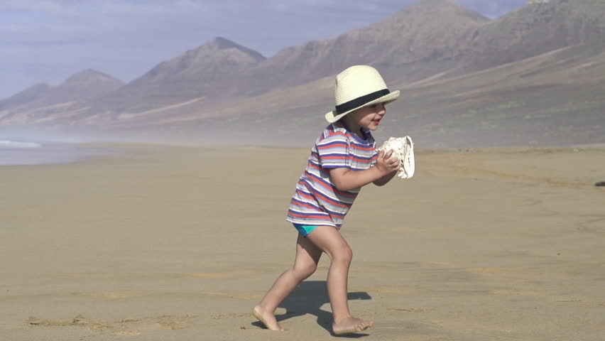 Boy with beautiful seashell on the beach, super slow motion, shot at 240fps
