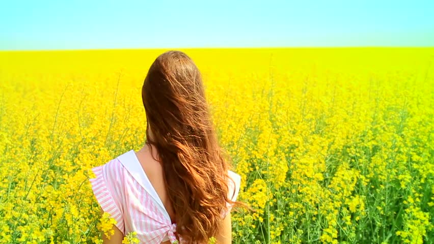 Beautiful Young Woman Standing in a Yellow Field Slow Motion HD