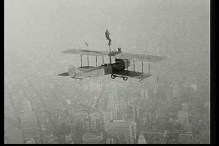 1920s - A man climbs a pole attached to a biplane in this 1928 stunt film.