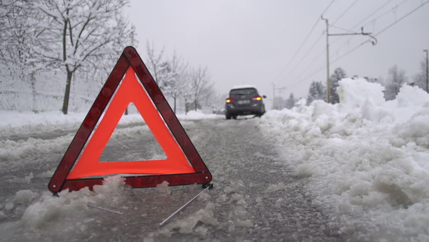 Warning triangle in front of a car breakdown