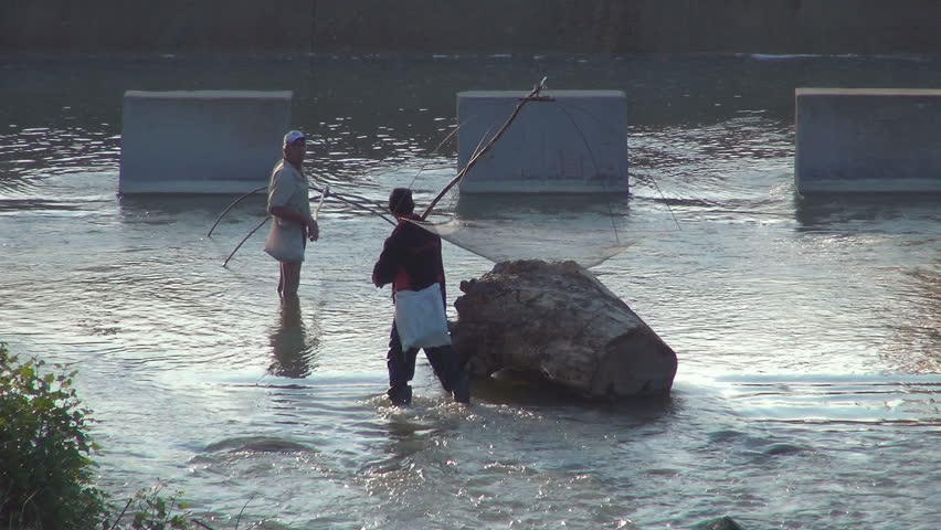 ARGES, ROMANIA, April 15, 2013, Poachers Men Fishing with a Net on a Prohibition Period in River, Poaching